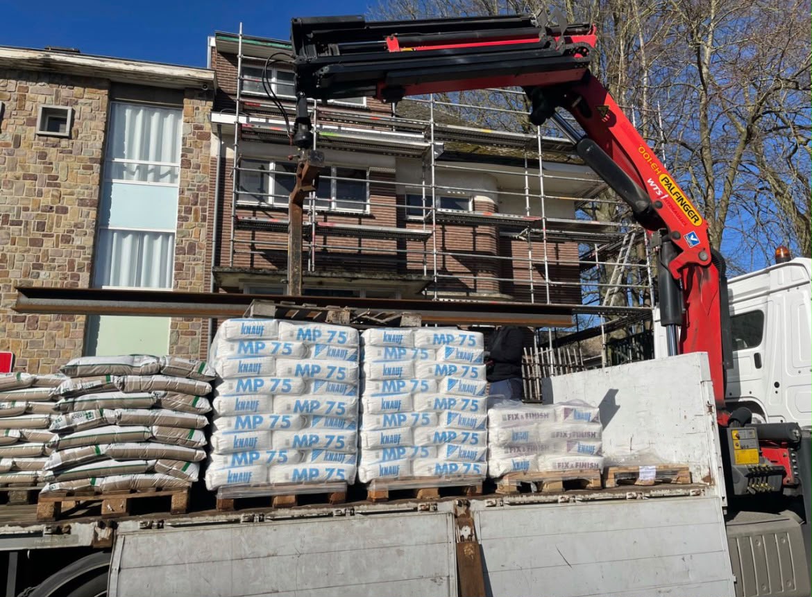 Aanvoer van bouwmaterialen met kraan